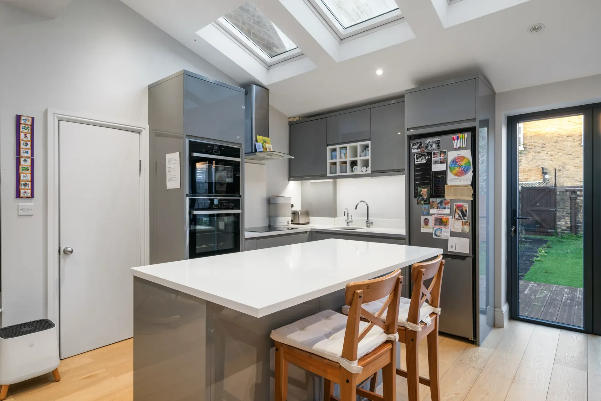 Fitted kitchen with a central island and doors to the garden
