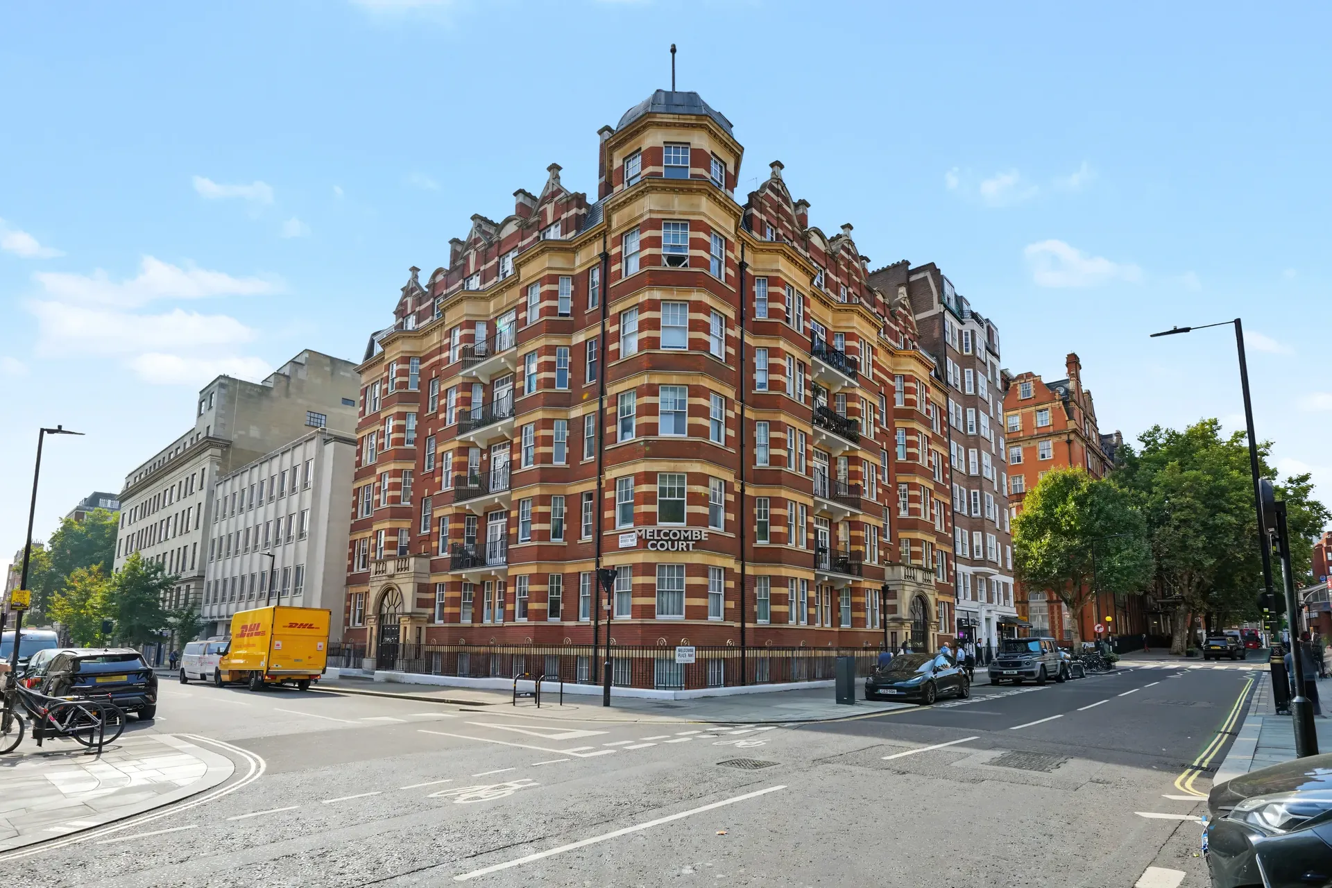 Red-brick mansion block with bay windows viewed from the street
