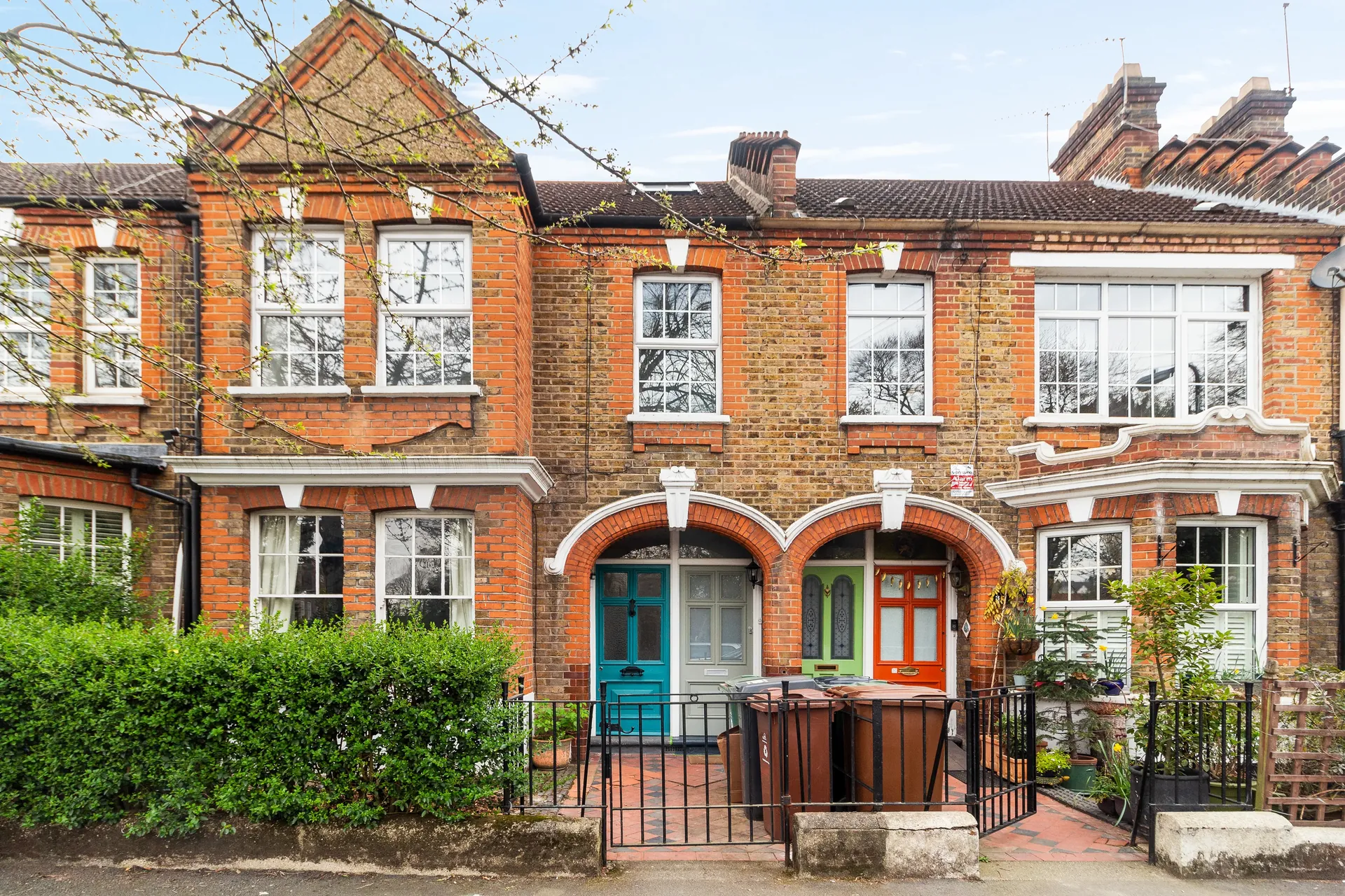 Red-brick terrace frontage with planted front gardens